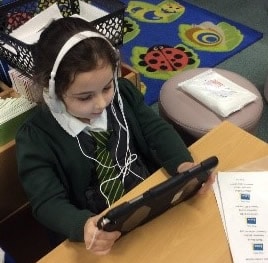 Pupil using iPad and earphones