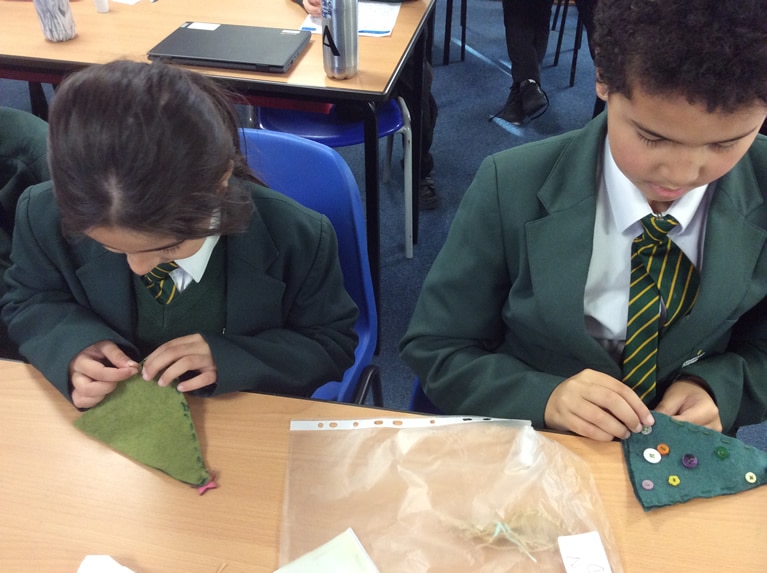 Year 5 pupils sewing their Christmas trees